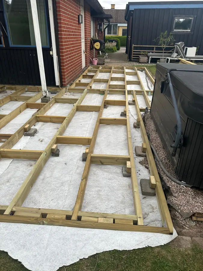 Regelstommen sträcker sig mellan huset och spabadet, uppburen av betongplintar.