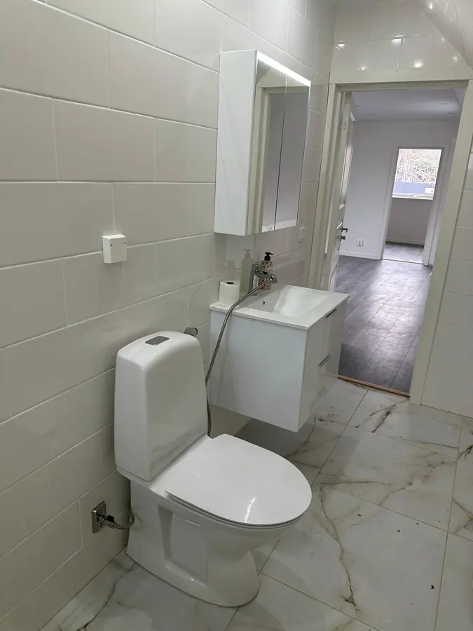 Toalett och handfat på plats, dörren öppen mot det nya vindsplanet.